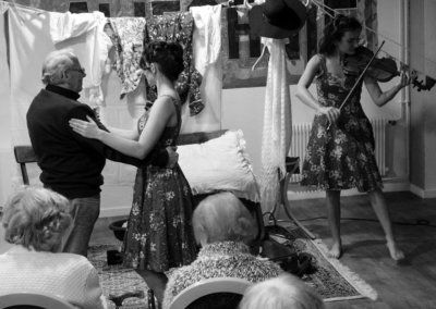 Spectacle Les p'tits papiers : Mathilde Mercier danse avec un monsieur pendant que Maïwenn Doherty joue du violon.